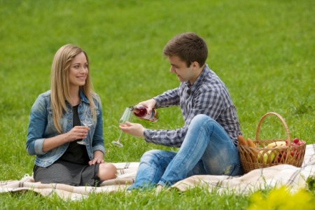 芝生でワインを飲むカップル