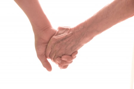 手をつなぐ若い男性と年上女性